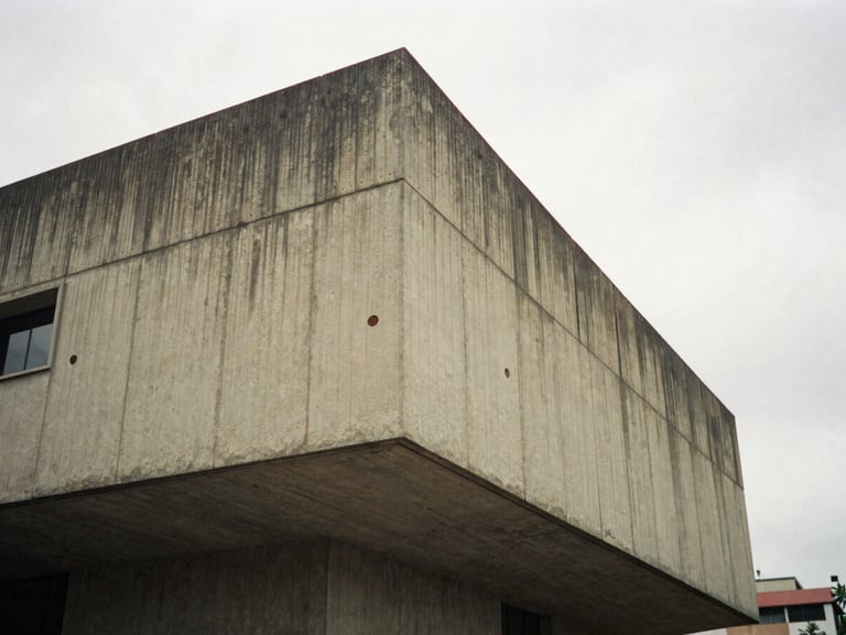 A dramatic angle of a brutalist concrete facade in Bogotá, overcast sky, soft shadows, architectural scale, 35mm film