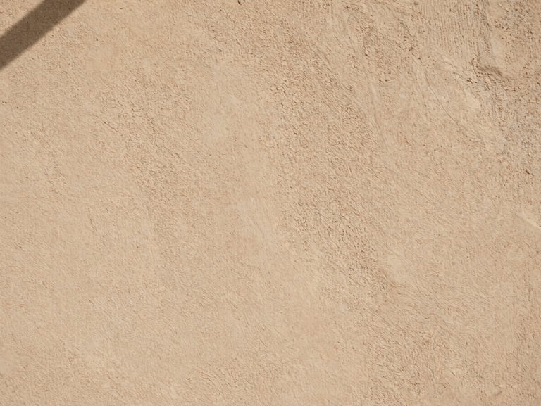 Extreme close-up of sustainable rammed earth wall texture, tactile details, warm architectural neutral colors, soft natural lighting.