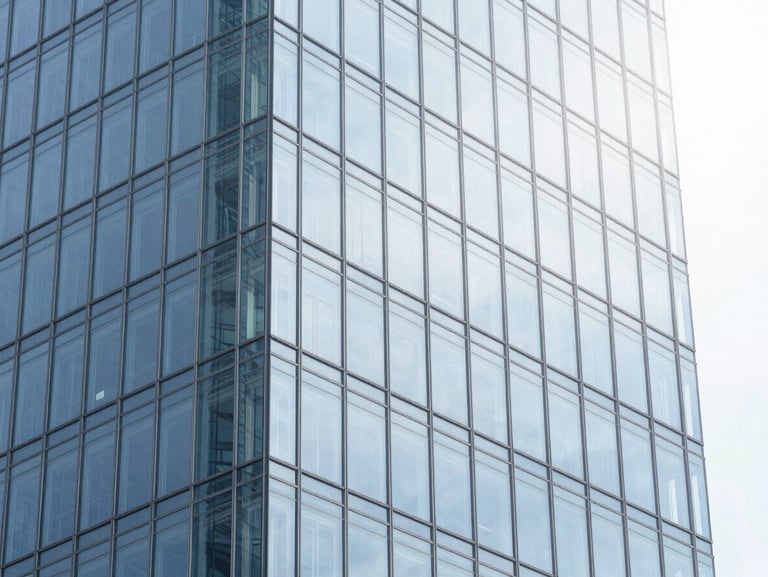 Modern glass skyscraper reflecting bright diffused daylight, clean architectural lines, cool blue tones