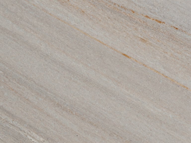 Extreme close-up of a natural quartzite slab with subtle warm veins, honed matte finish