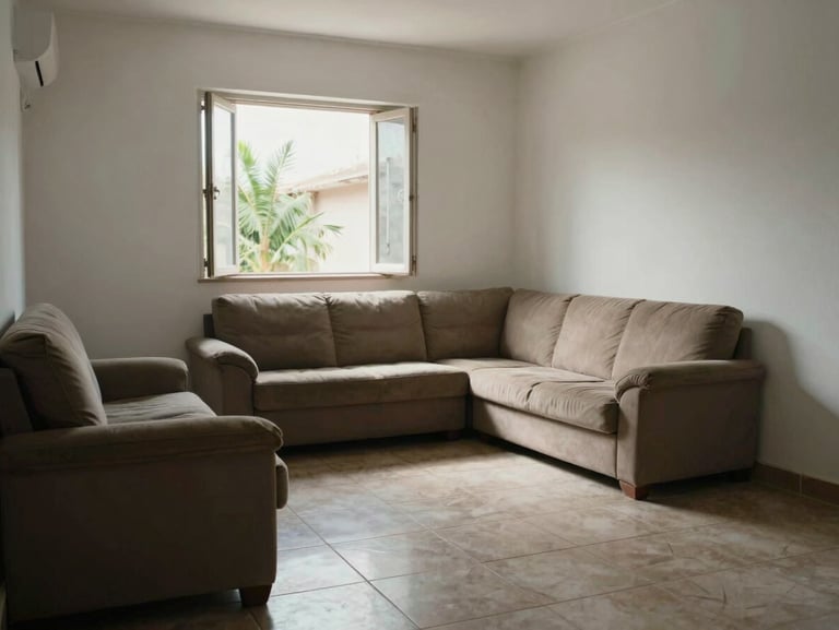 Living room of a modest Zona Norte house in morning daylight — tiled floor, simple sofa, white walls, natural light through open window, real everyday condition, no staging