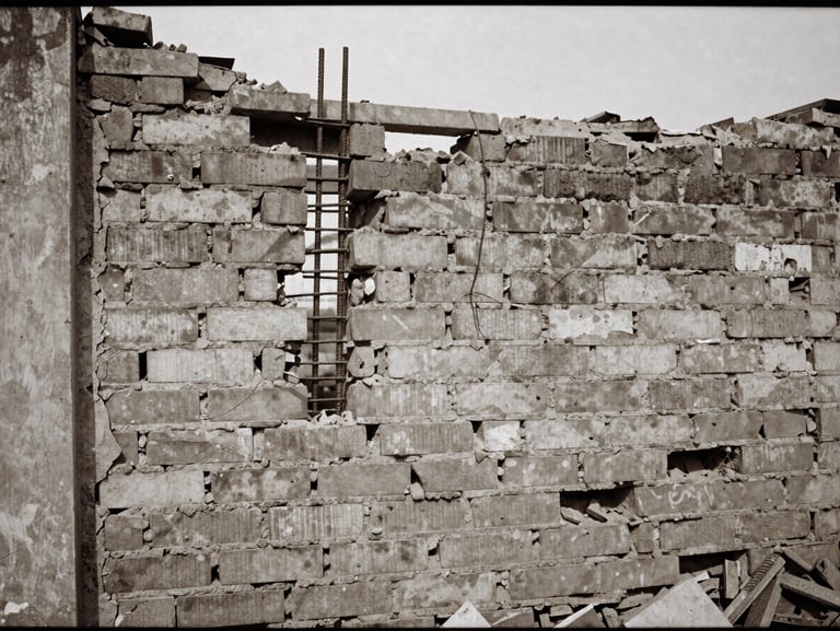 Gritty documentary film photograph of a demolished brick wall with steel rebar exposed, harsh natural daylight, muted earth tones, 35mm grain