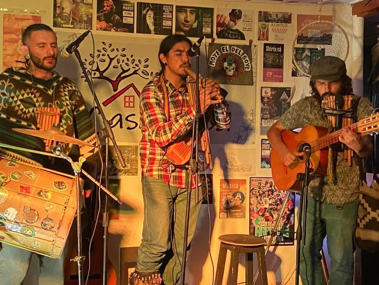Banda de folk en vivo interpretando música tradicional andina con zampoñas, flauta y guitarra 