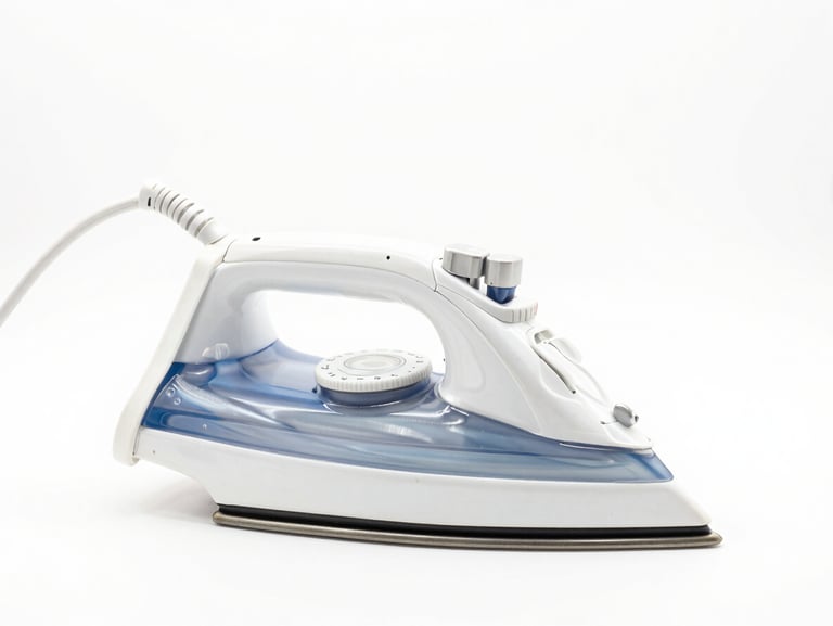 Bright high-key product photography of a heavy-soleplate electric iron, adjustable temperature dial visible, crisp white background