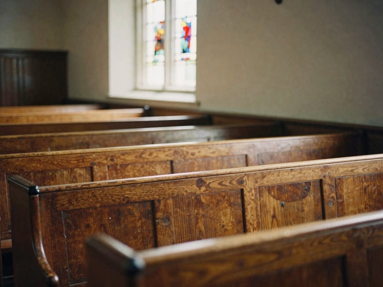 Worn wooden pews inside a quiet sanctuary, soft natural light streaming through a stained glass window, warm historic atmosphere, 35mm film aesthetic