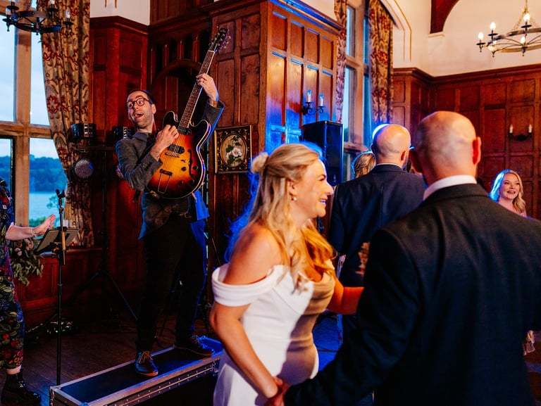 a man and woman playing guitar together in front of bride at wedding