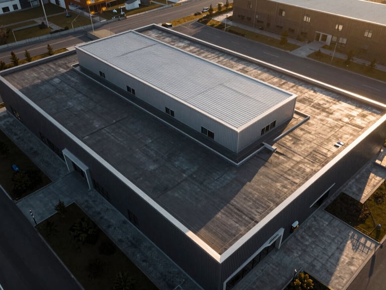 Top-down geometric drone shot of a modern commercial flat roof with clean lines and silver metal flashing