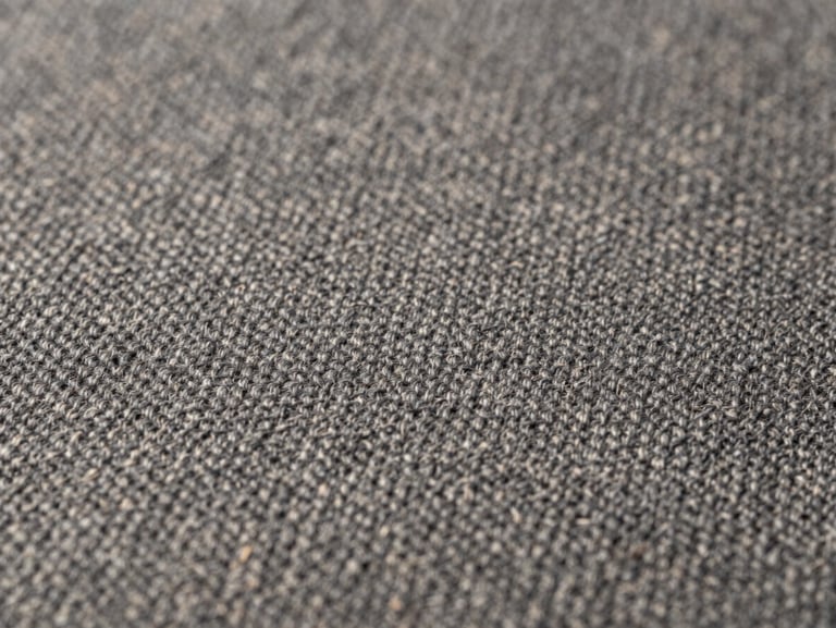 Macro close-up of premium charcoal wool fabric weave, showing precise stitching alignment and tension-free lay under soft diffused studio lighting, sharp focus, 35mm lens.