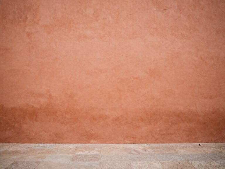 Warm terracotta walls of an old Spanish plaza, soft natural light, minimalist composition