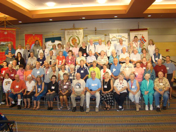 a larget group of lag members at a stevne posed in front of each lag's fane