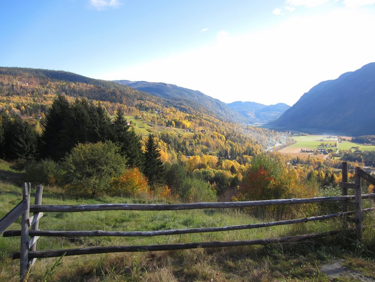 A wooden fence with mountains and a valley in the distance