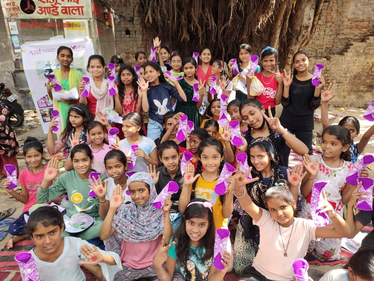 About thirty girls holding up their palms with red dots on.