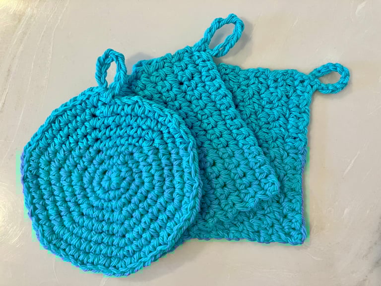 3 aqua colored crocheted face scrubbies stacked together