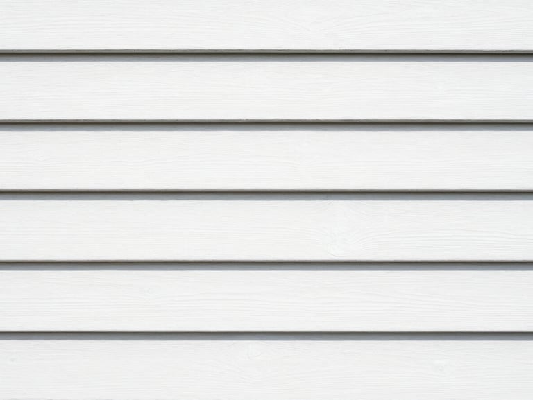 Close-up of the same exterior wood siding, now perfectly sanded, primed, and painted with crisp white coastal-grade paint, clean lines