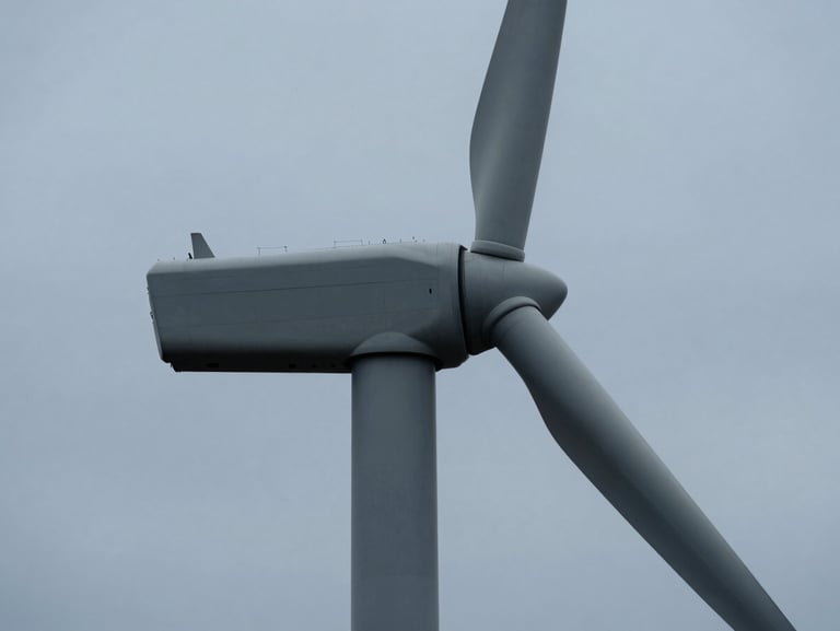 Close-up of a modern wind turbine base with clean architectural lines against a cool overcast sky