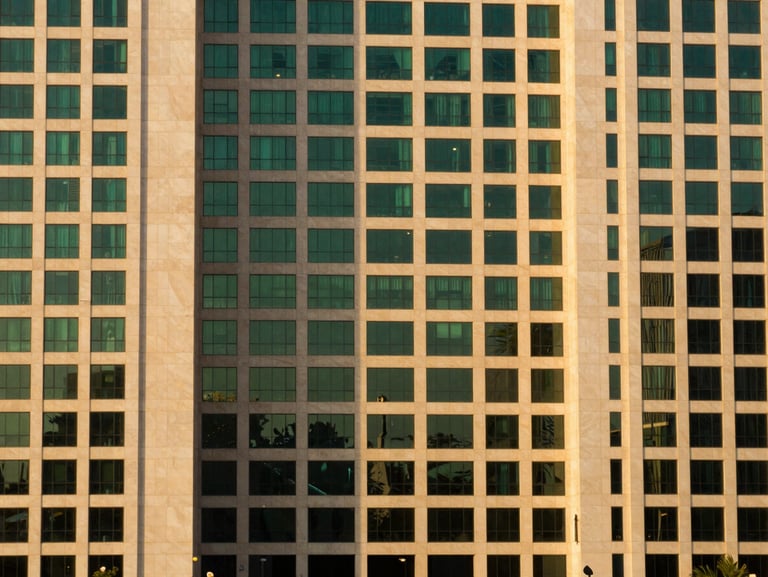 Clean architectural detail of prime commercial land in a modern business district in Karachi, warm evening light, 35mm