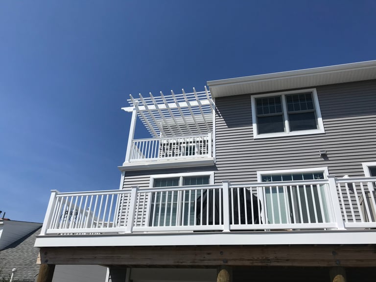 Vinyl pergola system integrated into deck railing