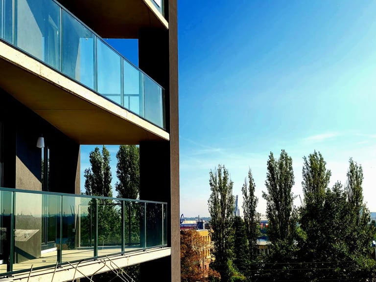Przestronne balkony ze szklaną balustradą – apartamenty na sprzedaż w Szczecinie z widokiem na ziele