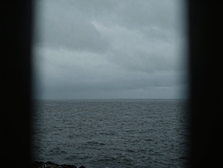 Moody cinematic shot of Dublin bay under an overcast sky, low-key dramatic lighting, desaturated cool tones, anamorphic lens framing, high contrast, 35mm grain