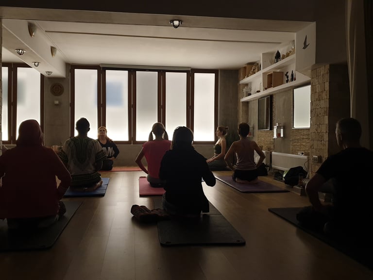 Meditație ghidată la cursul de yoga tradițională din București – practicanți în vajrasana
