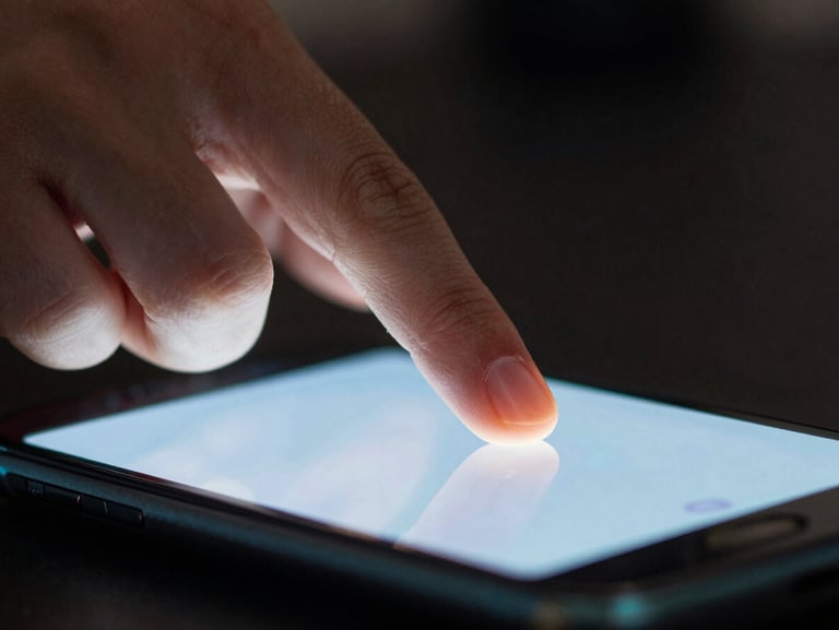 Extreme close-up of fingers interacting with a glowing mobile screen in a dark room, sharp cyan rim lighting reflecting on the glass.