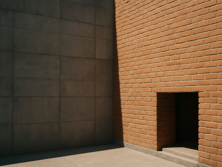 Exterior facade of Casa Materia, raw concrete blocks meeting hand-laid terracotta bricks under high-contrast afternoon sun.