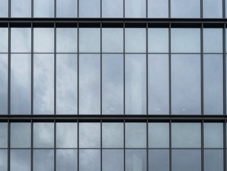 Minimalist corporate glass facade reflecting a cold silver sky, sharp focus, architectural photography, 35mm