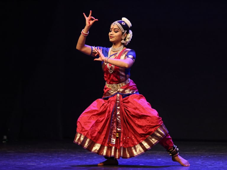 A classical Indian dancer in mid-spin, traditional costume, dramatic stage lighting, capturing precise hand mudras
