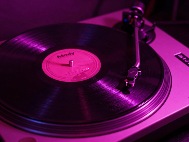 Moody close-up of a vinyl record spinning on a turntable under neon magenta lighting