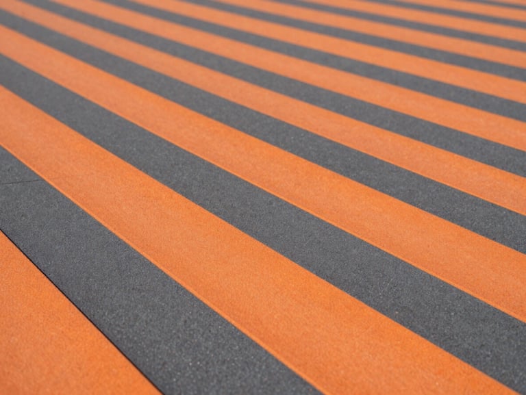 Macro texture shot of orange and charcoal interlocking PP sports tiles, clean architectural lines, high-contrast industrial tones