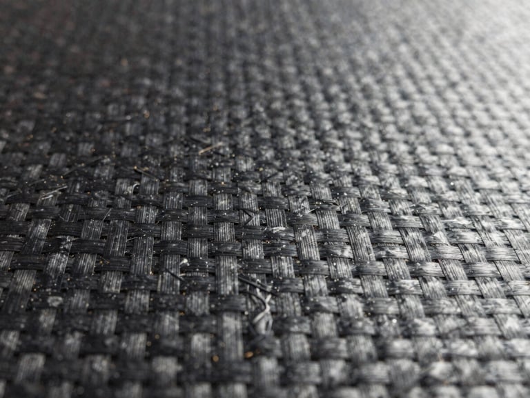 Extreme close-up of structural carbon fiber weave texture, crisp industrial studio lighting, sharp focus on composite fibers.
