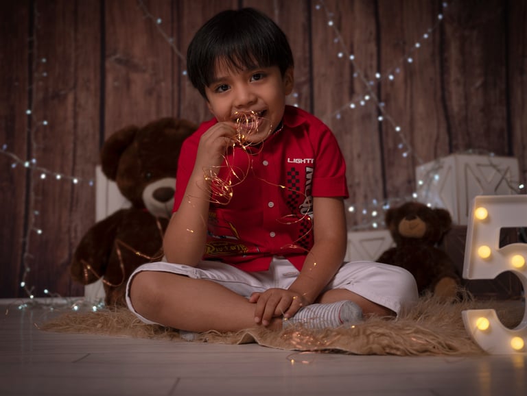 a young boy sitting on a rug with a teddy bear