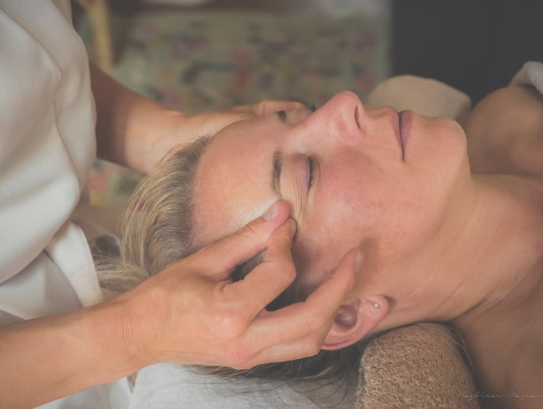 Massage relaxant du visage avec les doigts durant un soin du visage