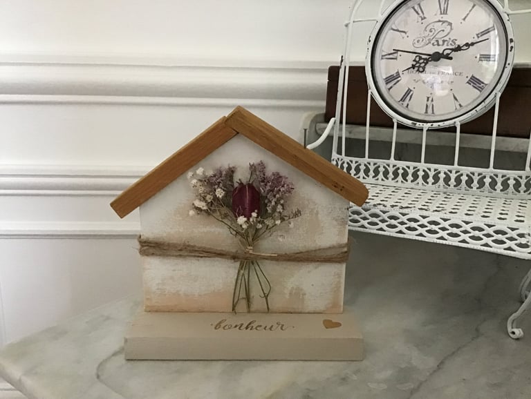décoration en bois en forme de maison avec des fleurs séchées