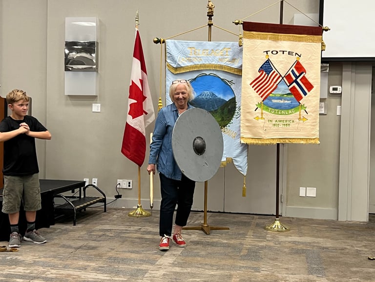 a woman and a child demonstrating viking weapons