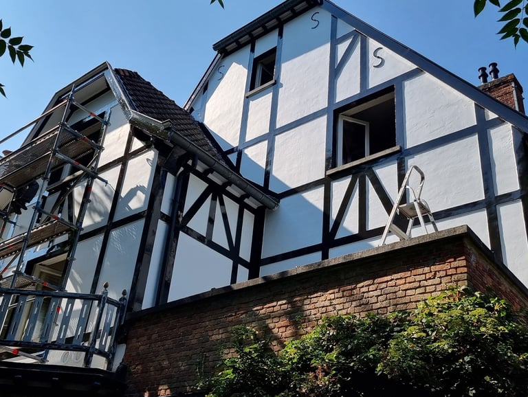 Witte Gevel bijpleistering van het huis met zwarte accenten, moderne stijl.