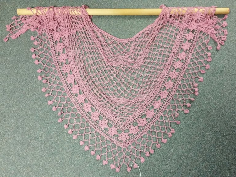 A pink hand-made lace shawl.