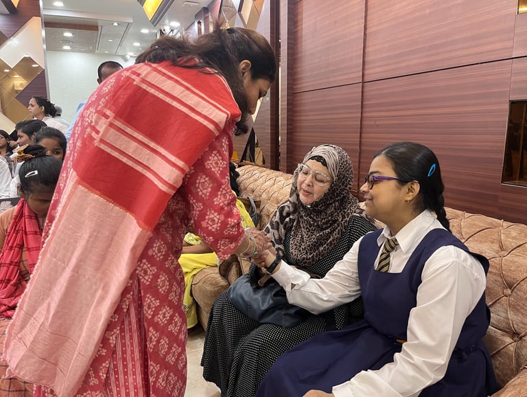An image of Shruti communicating with deaf blind student Sarah Moin by writing on her hand.