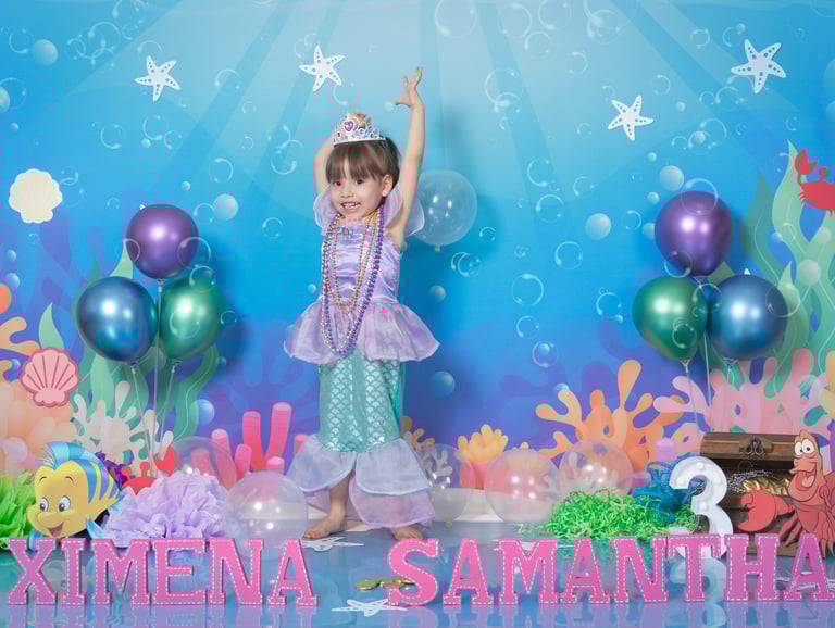 a little girl in a mermaid costume at a birthday party