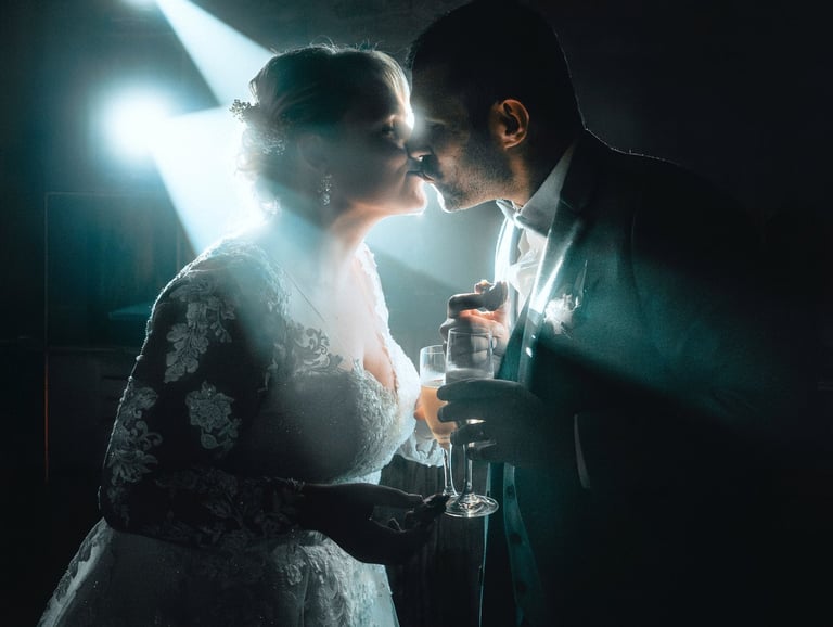 un couple s'embrassant lors de leur soirée de mariage couvert par un photographe 