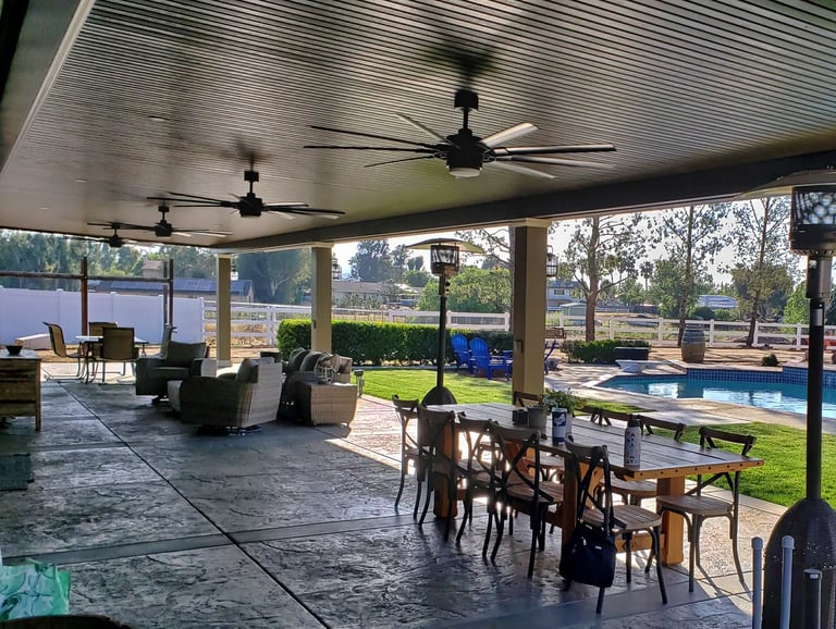 Brown patio cover in large backyard with pool.