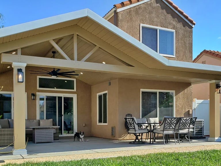 Alumawood patio cover with gable roof line, lights, and ceiling fan.