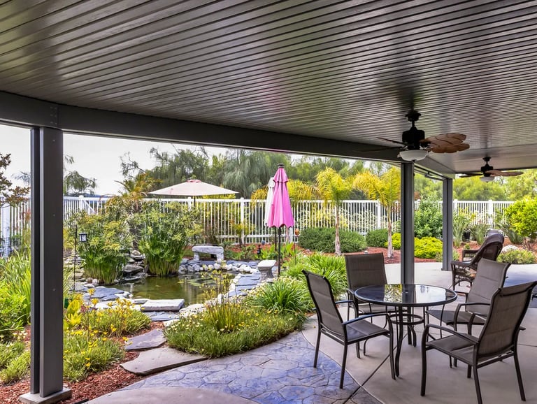 Amazing backyard with tropical plants and fish pond veiwed from under a covered patio.