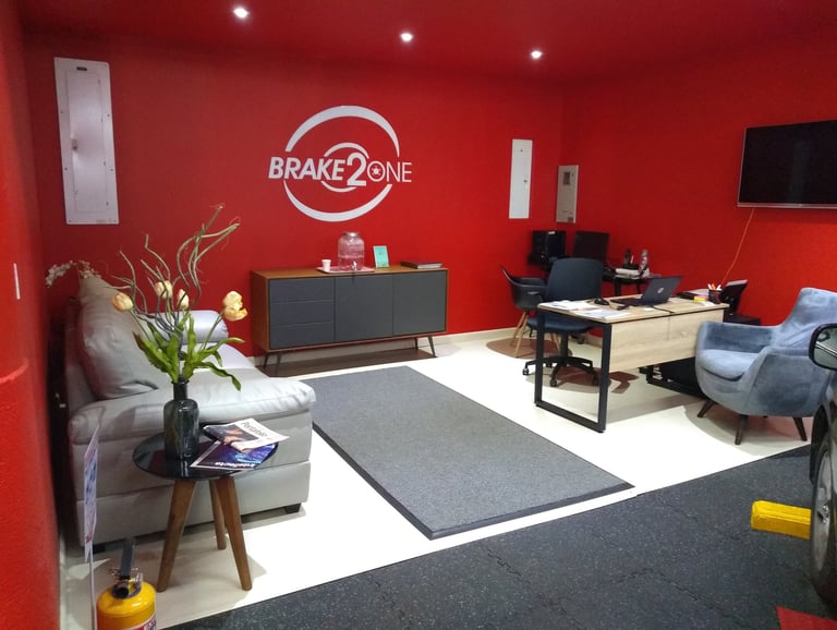 Área de recepción cómoda y atención al cliente en taller automotriz especializado en frenos