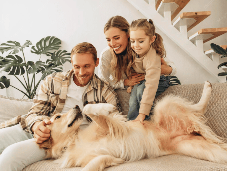 Happy family with a young daughter petting their golden retriever dog on a living room sofa.