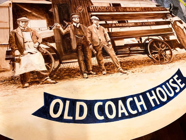 Close-up of angled pub sign with painted brewery staff