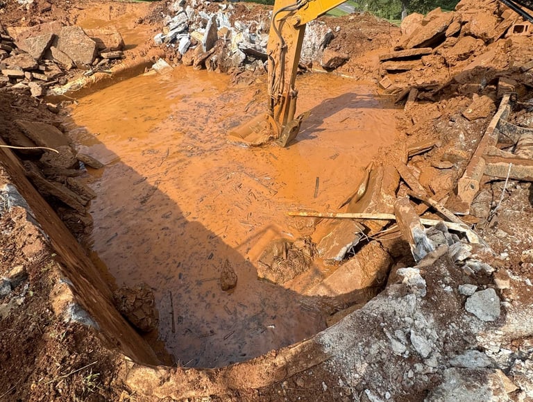 excavator digging out concrete pool