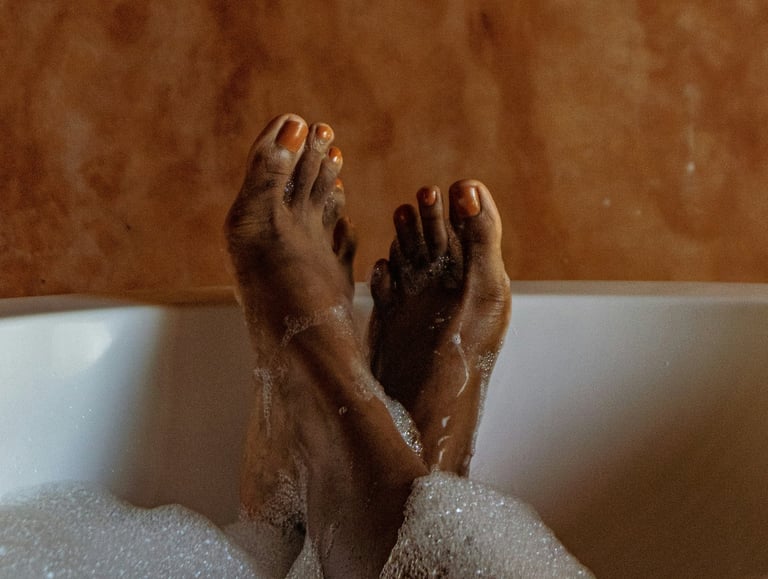a person's feet in a bathtub with soap bubbles ( ionic foot detox )