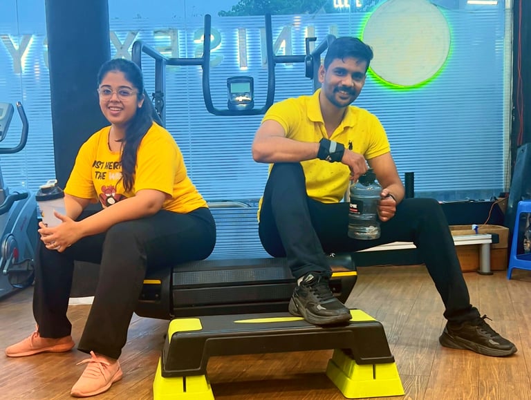 a man and woman sitting on a bench in a gym