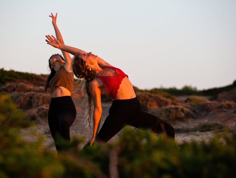two women doing yoga in nature